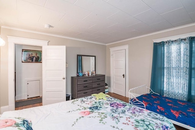 bedroom with dark hardwood / wood-style floors and crown molding