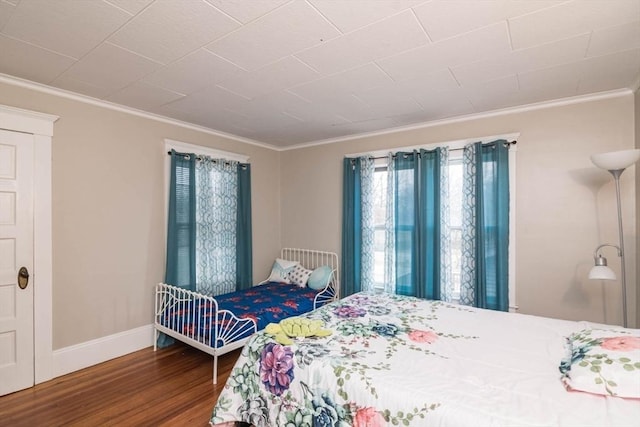 bedroom with dark wood-type flooring and ornamental molding