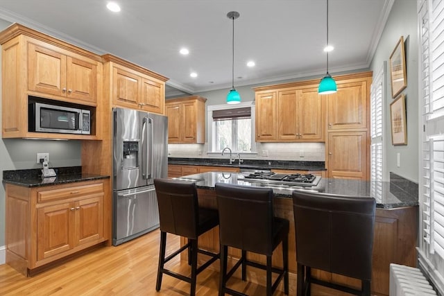 41 Clarke St, Lexington, MA 02421 - kitchen featuring appliances with stainless steel finishes, crown molding, a breakfast bar area, light wood-style floors, and hanging light fixtures