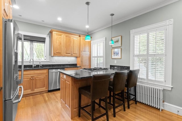 41 Clarke St, Lexington, MA 02421 - kitchen featuring radiator heating unit, appliances with stainless steel finishes, light wood finished floors, a sink, and ornamental molding