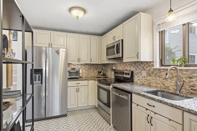 34 Staffordshire Ln Unit 34, Concord, MA 01742 - kitchen featuring stainless steel appliances, a sink, backsplash, light stone countertops, and pendant lighting