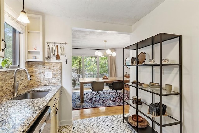 34 Staffordshire Ln Unit 34, Concord, MA 01742 - kitchen featuring a sink, decorative backsplash, a textured ceiling, light stone countertops, and decorative light fixtures