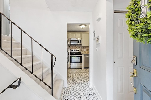 34 Staffordshire Ln Unit 34, Concord, MA 01742 - entryway with stairs, light tile patterned floors, and baseboards
