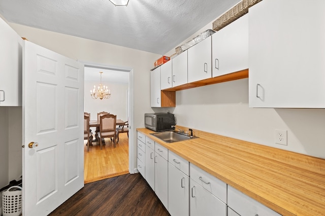 78 Holden Rd, Paxton, MA 01612 - kitchen with stainless steel microwave, a sink, dark wood-style floors, a chandelier, and light countertops