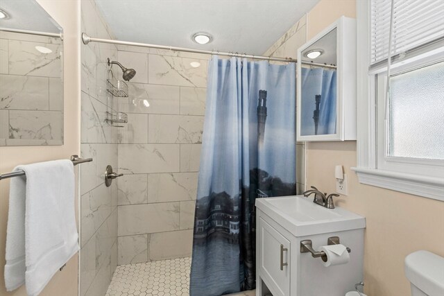 bathroom featuring a shower with shower curtain, toilet, and sink