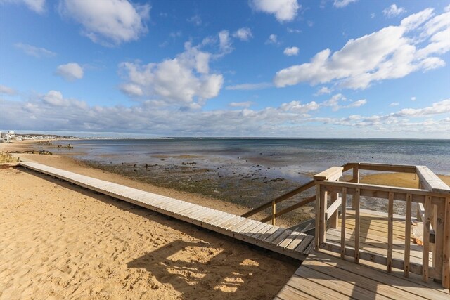 view of property's community with a water view and a beach view