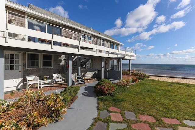 exterior space featuring a water view and a beach view