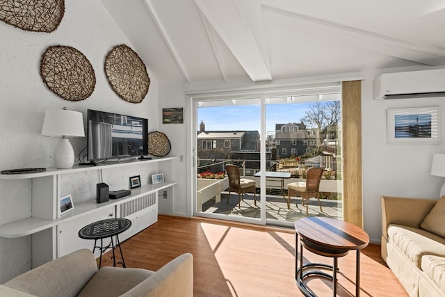 living room featuring a wall unit AC, lofted ceiling with beams, and hardwood / wood-style flooring