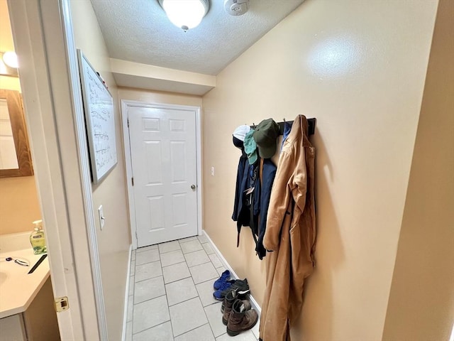 doorway with light tile patterned floors and a textured ceiling