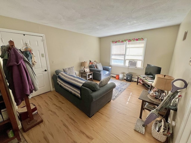 living room with baseboard heating, light hardwood / wood-style flooring, cooling unit, and a textured ceiling