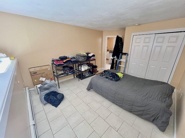 tiled bedroom featuring a textured ceiling and a closet