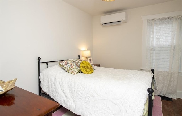 bedroom with wood finished floors and a wall mounted AC