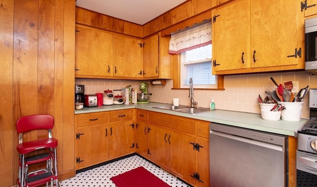 kitchen featuring a sink, light countertops, appliances with stainless steel finishes, light floors, and tasteful backsplash