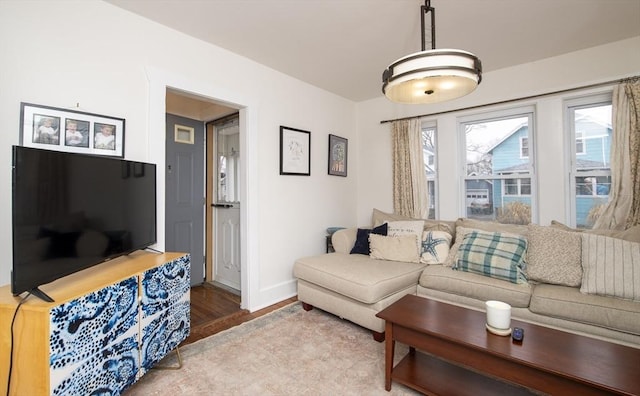 living area featuring baseboards and wood finished floors