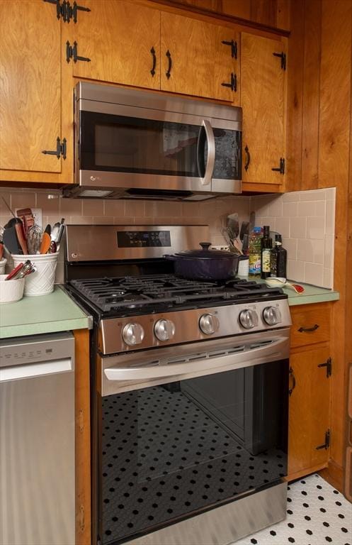 kitchen featuring appliances with stainless steel finishes, light countertops, brown cabinets, and decorative backsplash