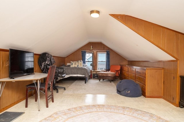 bedroom with lofted ceiling and wood walls