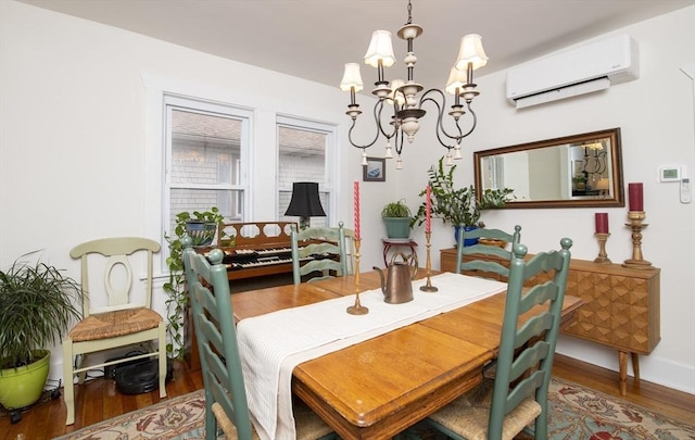 dining area featuring an AC wall unit, wood finished floors, and a notable chandelier