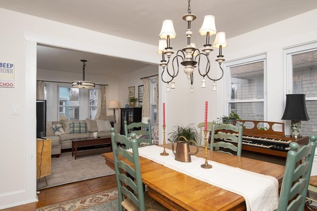 dining area with wood finished floors and a notable chandelier