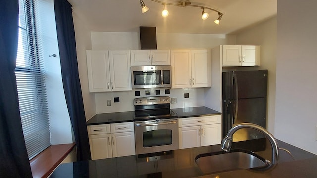 kitchen with appliances with stainless steel finishes, white cabinetry, and sink