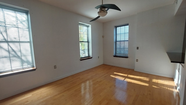 spare room with ceiling fan, a healthy amount of sunlight, and light hardwood / wood-style flooring