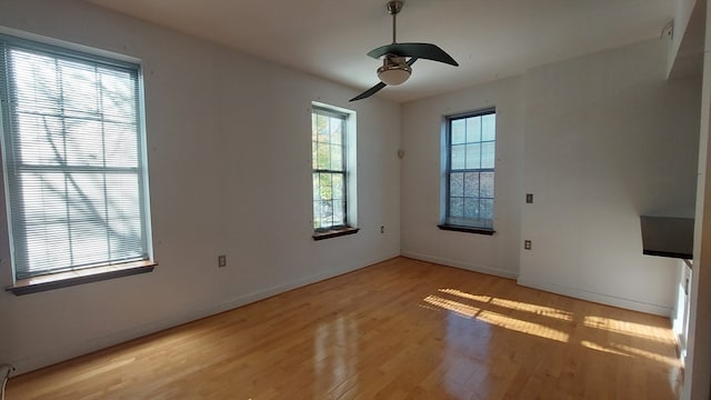 spare room with ceiling fan, light hardwood / wood-style flooring, and a healthy amount of sunlight