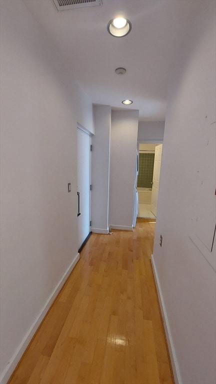 hallway with light hardwood / wood-style floors