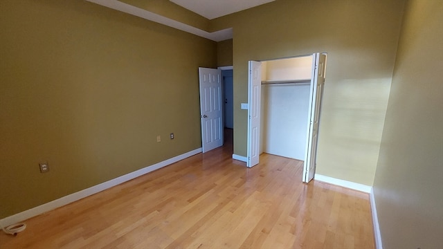 unfurnished bedroom featuring light hardwood / wood-style flooring and a closet