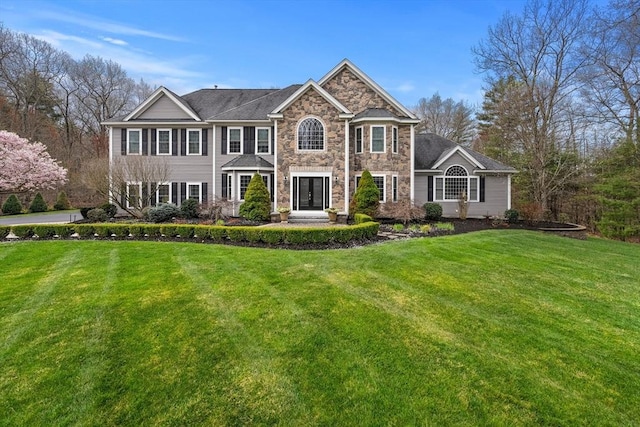 19 Cardiff Rd, Windham, NH 03087 - view of front of house with stone siding, a front yard, and french doors