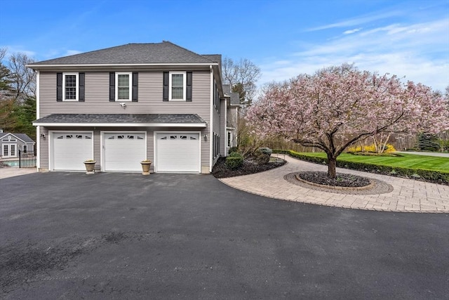 19 Cardiff Rd, Windham, NH 03087 - view of side of home featuring driveway, an attached garage, and roof with shingles