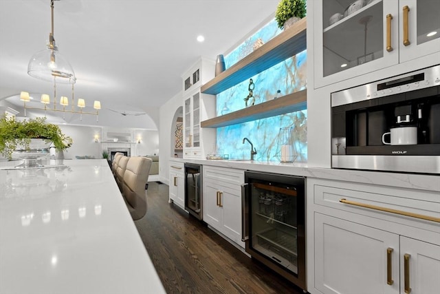 19 Cardiff Rd, Windham, NH 03087 - indoor wet bar featuring beverage cooler, dark wood-style floors, a fireplace, and decorative light fixtures
