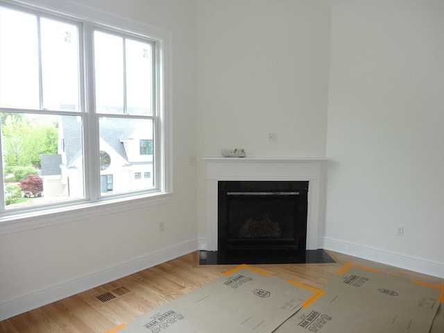 163 Johnson Woods Dr Unit 163, Reading, MA 01867 - unfurnished living room featuring a fireplace with flush hearth, baseboards, and wood finished floors