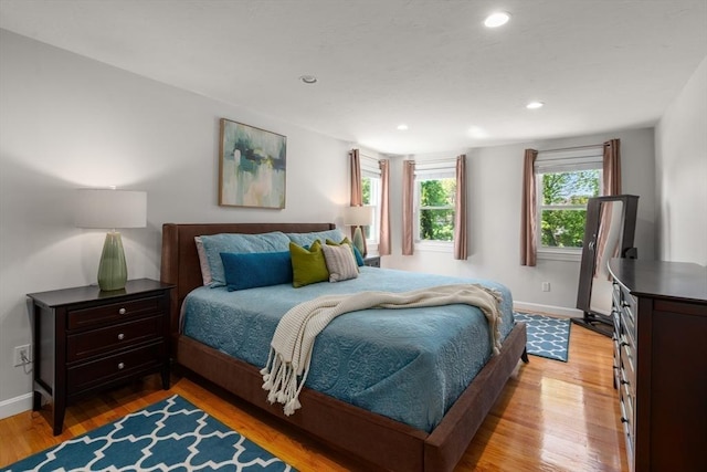 bedroom featuring baseboards, light wood finished floors, and recessed lighting