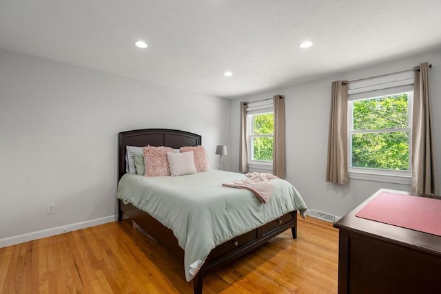 bedroom with baseboards, light wood finished floors, and recessed lighting