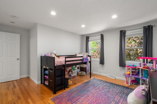 bedroom featuring wood finished floors, baseboards, and recessed lighting