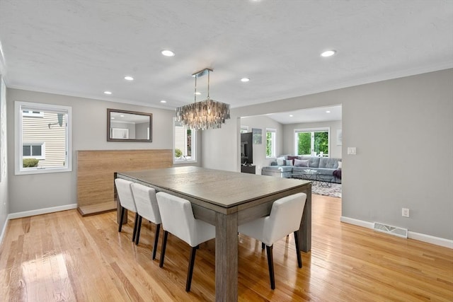 dining room featuring baseboards, recessed lighting, light wood finished floors, a chandelier, and crown molding