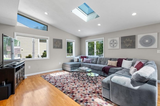 living room featuring a skylight, light wood-style floors, vaulted ceiling, recessed lighting, and baseboards
