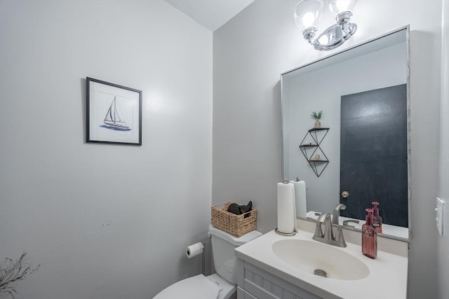 bathroom with vanity, a textured ceiling, and toilet