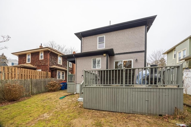 back of property featuring a lawn and a wooden deck