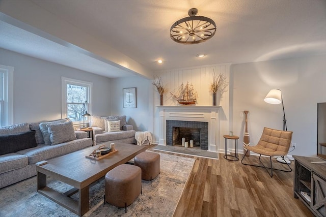 living room featuring hardwood / wood-style flooring and a brick fireplace