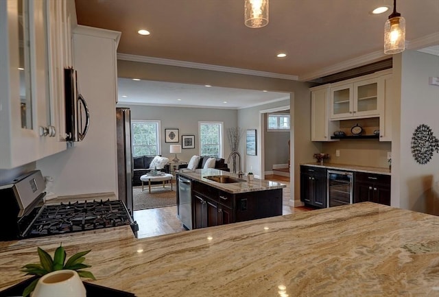 kitchen with sink, appliances with stainless steel finishes, a center island, wine cooler, and decorative light fixtures