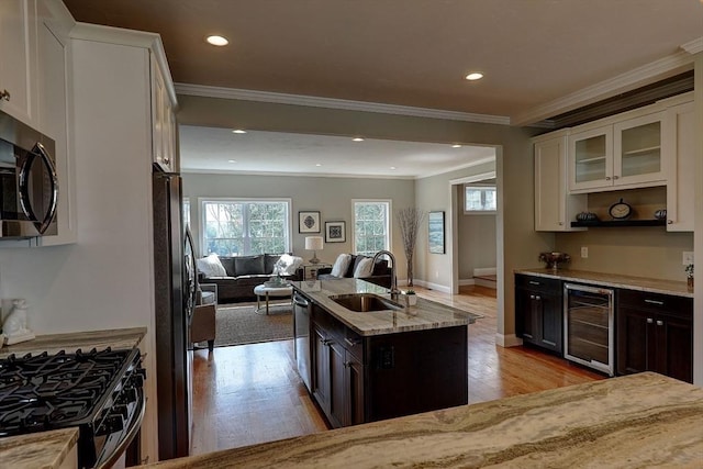 kitchen featuring white cabinetry, appliances with stainless steel finishes, beverage cooler, and dark brown cabinets