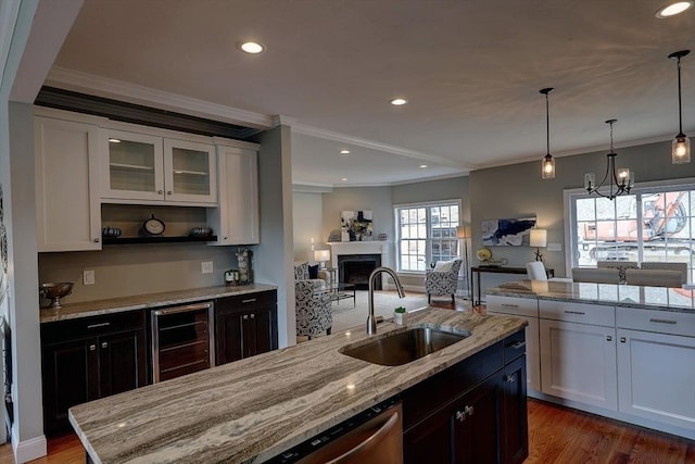 kitchen with ornamental molding, sink, pendant lighting, and white cabinets