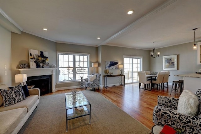 living room featuring crown molding, light hardwood / wood-style flooring, and a chandelier