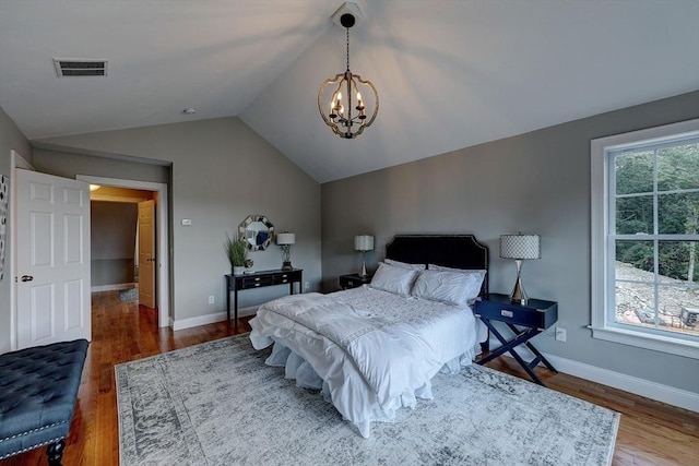 bedroom featuring lofted ceiling, dark hardwood / wood-style floors, and an inviting chandelier