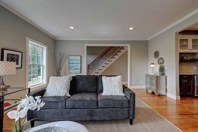 living room featuring wine cooler, light hardwood / wood-style flooring, and ornamental molding