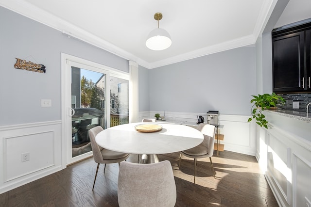 dining space with dark wood-type flooring and crown molding