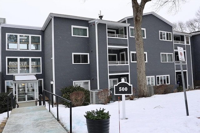 snow covered property featuring central AC