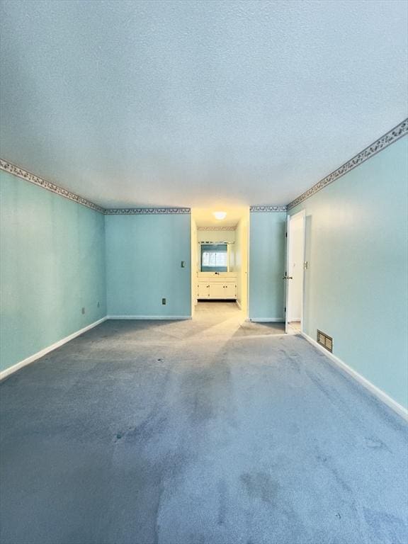 carpeted empty room featuring a textured ceiling