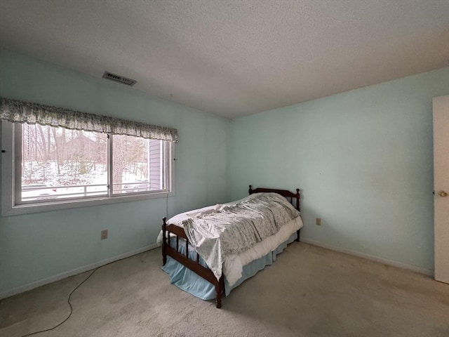 bedroom featuring light carpet and a textured ceiling