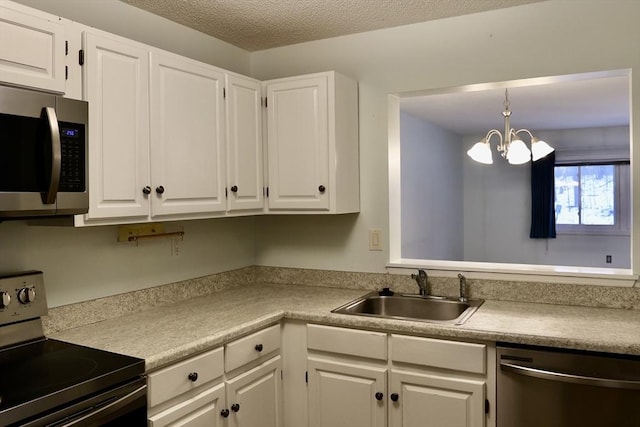 kitchen featuring sink, white cabinetry, decorative light fixtures, a textured ceiling, and stainless steel appliances